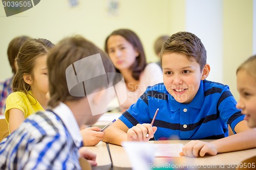 Image of group of school kids writing test in classroom