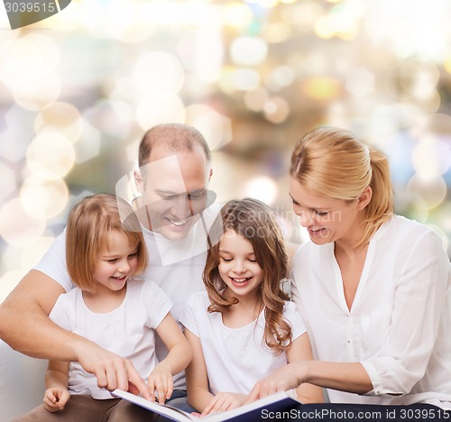 Image of happy family with book at home