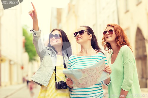 Image of smiling teenage girls with map and camera