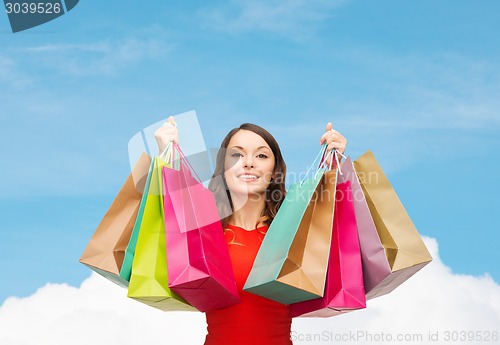 Image of smiling woman with colorful shopping bags