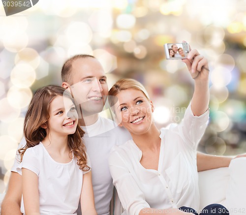 Image of happy family with camera at home