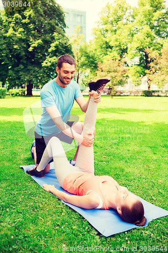 Image of smiling couple stretching outdoors