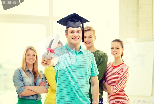 Image of smiling male student with diploma and corner-cap