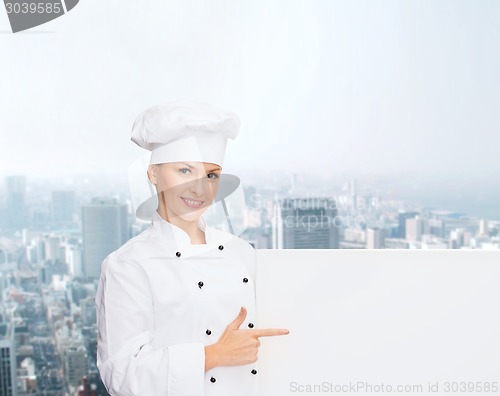 Image of smiling female chef with white blank board