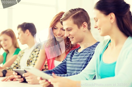 Image of smiling students with tablet pc at school