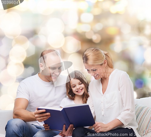 Image of happy family with book at home