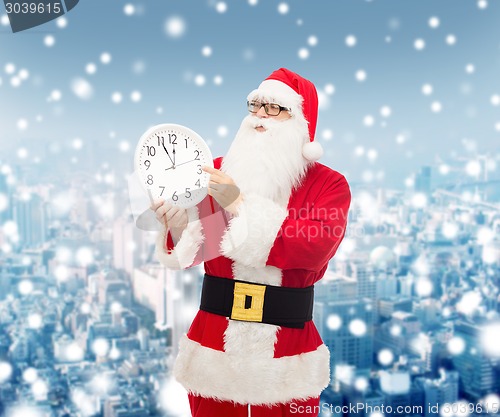 Image of man in costume of santa claus with clock