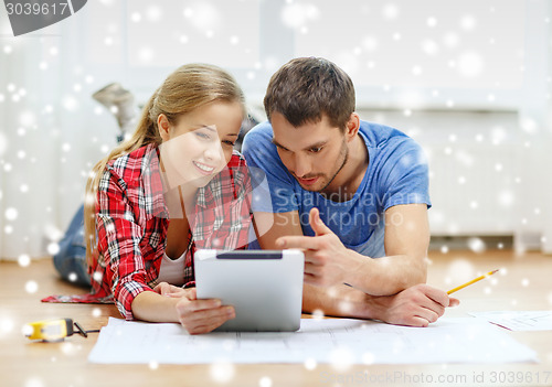 Image of smiling couple with tablet pc at home
