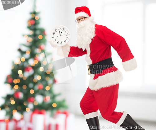 Image of man in costume of santa claus with clock