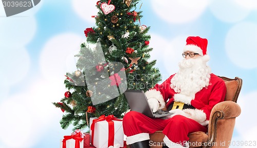 Image of man in costume of santa claus with laptop