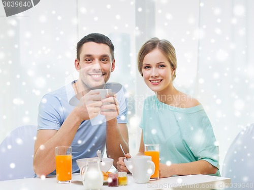 Image of smiling couple having breakfast at home