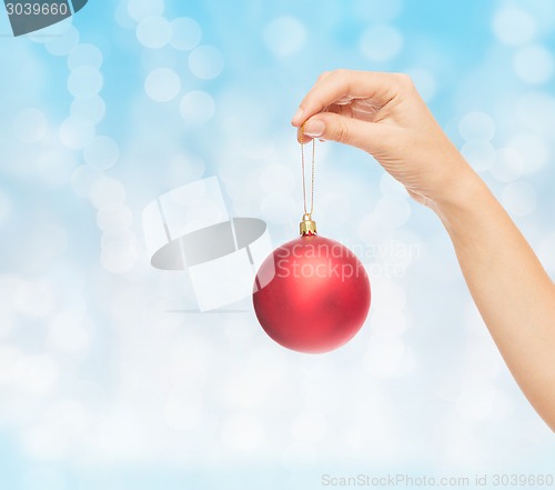 Image of close up of woman in sweater with christmas ball