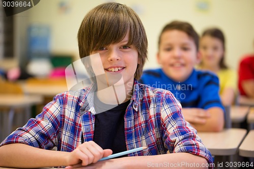 Image of group of school kids with notebooks in classroom