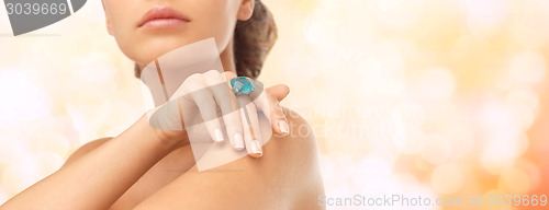 Image of closeup of woman hand with big blue cocktail ring