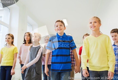 Image of group of smiling school kids walking in corridor