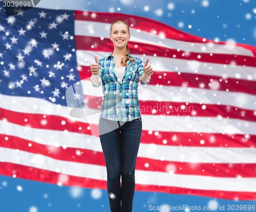 Image of smiling girl in casual clothes showing thumbs up