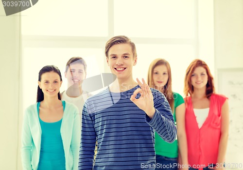 Image of students with teenager in front showing ok sign