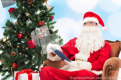 Image of man in costume of santa claus with tablet pc