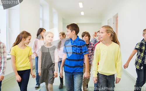 Image of group of smiling school kids walking in corridor