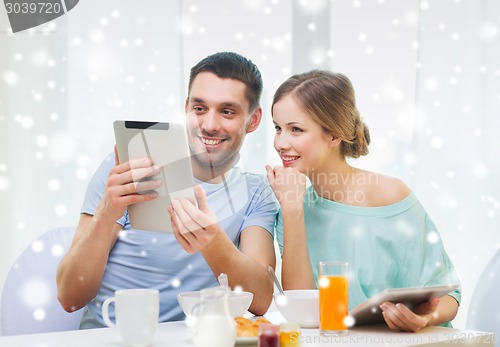 Image of smiling couple with tablet pc having breakfast