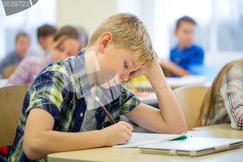 Image of group of school kids writing test in classroom