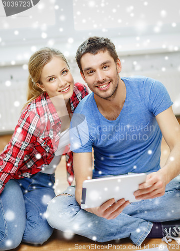 Image of smiling couple with tablet pc at home