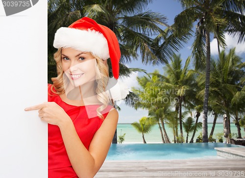 Image of smiling young woman in santa hat with white board