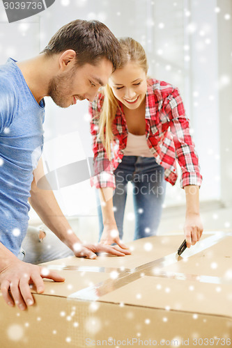 Image of smiling couple opening big cardboard box