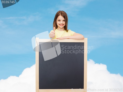 Image of happy little girl with blank blackboard