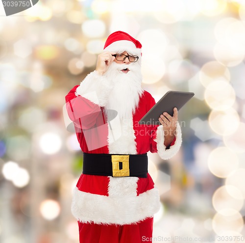 Image of man in costume of santa claus with tablet pc