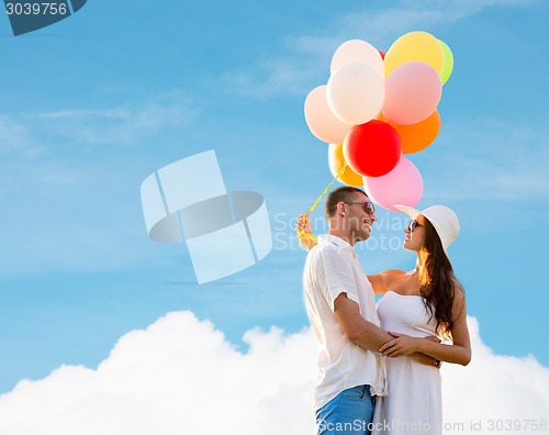 Image of smiling couple with air balloons outdoors