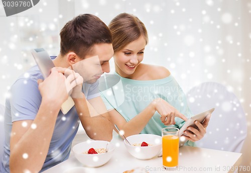 Image of smiling couple with tablet pc having breakfast