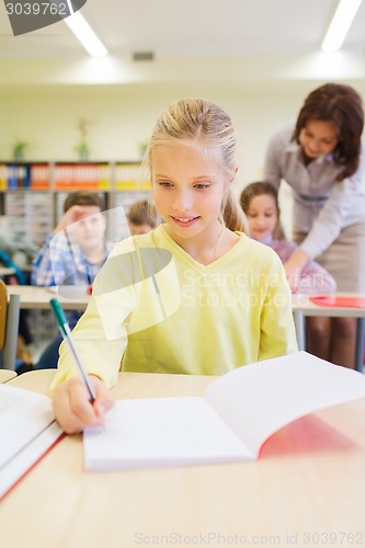 Image of group of school kids writing test in classroom