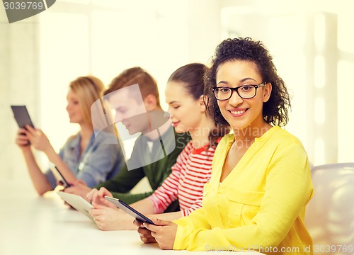 Image of smiling female students with tablet pc at school