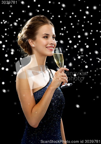 Image of smiling woman holding glass of sparkling wine