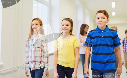Image of group of smiling school kids walking in corridor