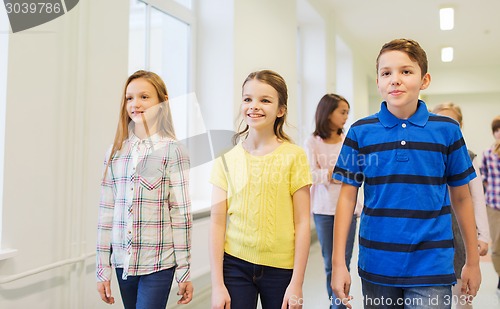 Image of group of smiling school kids walking in corridor