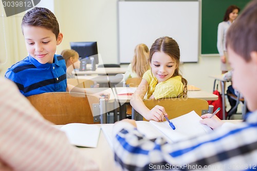 Image of group of school kids writing test in classroom