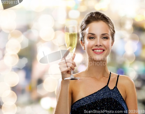 Image of smiling woman holding glass of sparkling wine