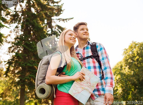 Image of smiling couple with map and backpack in nature