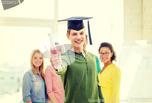 Image of smiling male student with diploma and corner-cap