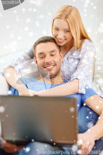 Image of smiling happy couple with laptop at home