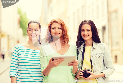 Image of smiling teenage girls with tablet pc and camera