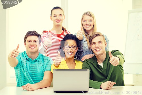 Image of smiling students with laptop at school