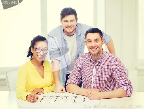 Image of three smiling architects working in office