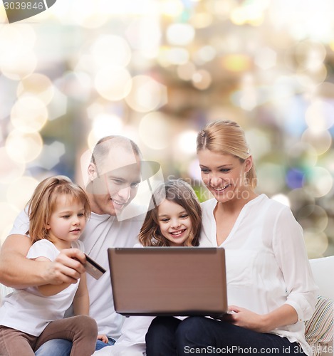 Image of happy family with laptop computer and credit card