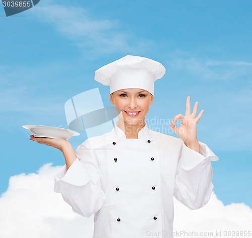 Image of female chef with empty plate showing ok sign