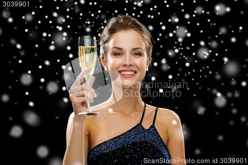 Image of smiling woman holding glass of sparkling wine