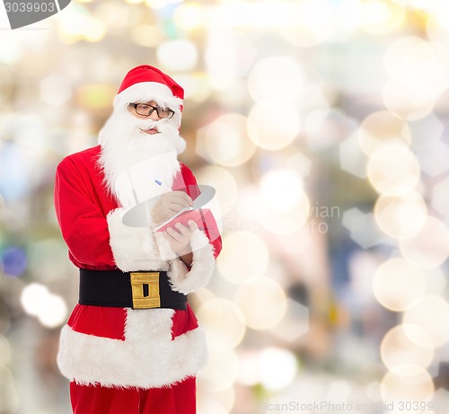 Image of man in costume of santa claus with notepad