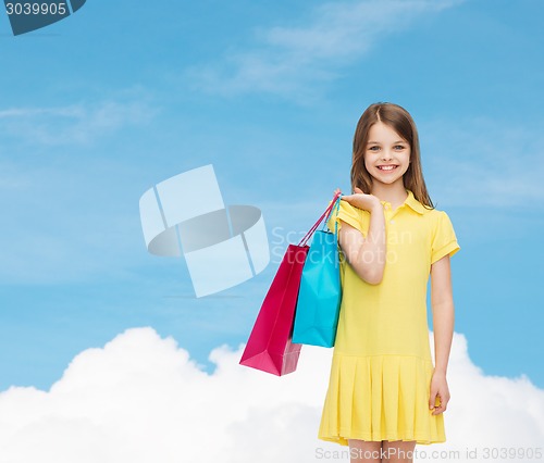 Image of smiling little girl in dress with shopping bags